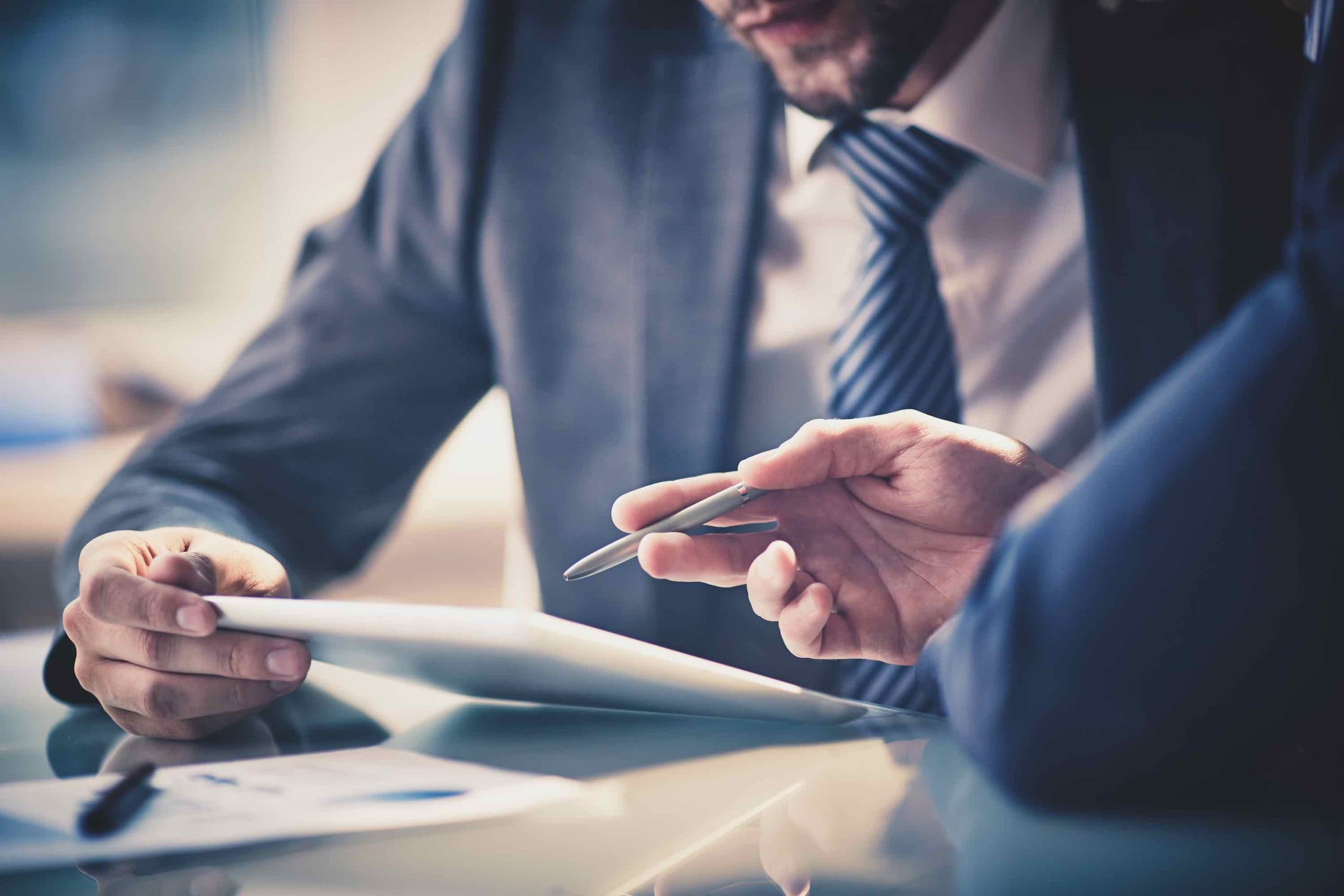Two professionals reviewing finance documents on a tablet